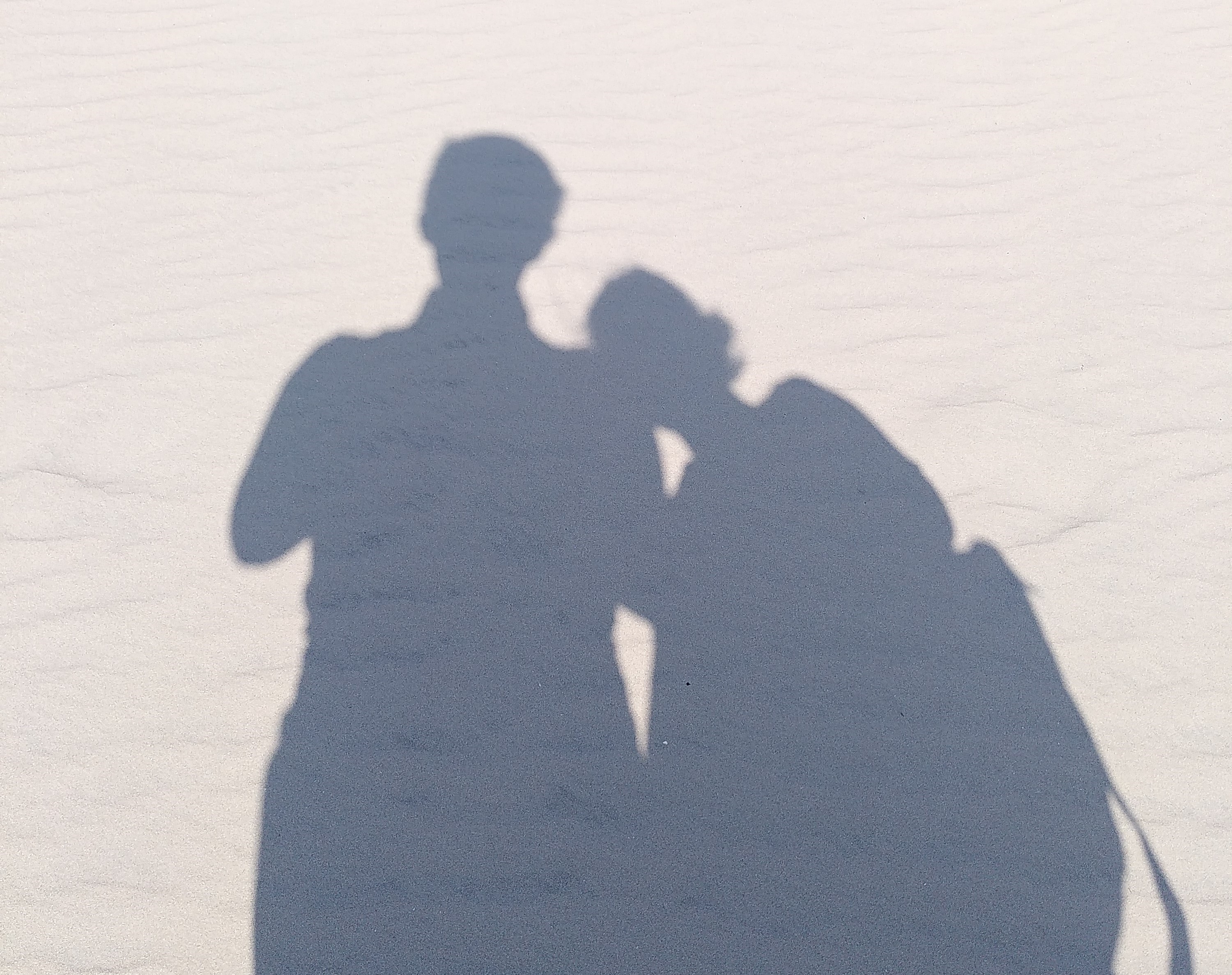 Les ombres des futurs mariés, Clothilde et Paul, projetées sur le sable
